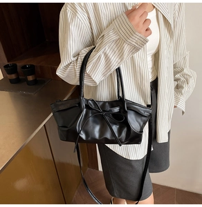 Close-up of a black PU leather tote bag with a bow knot and detachable shoulder strap