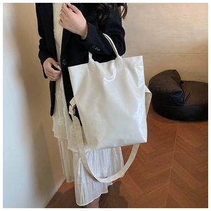 Detail view of white PU leather tote bag showing reinforced handles and glossy finish