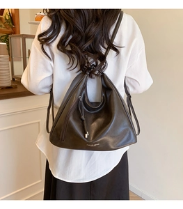 Close-up of brown faux leather tote bag with white Fashion & Bags text and zipper detail