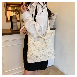 Détail du sac cabas en tricot crème avec perles et texture géométrique évidée