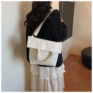 Detailed view of cream white soft PU leather tote bag shown on model with shoulder strap