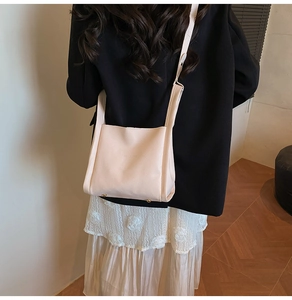 Detail of lychee pattern faux leather bucket bag with gold rivets and brand embossing