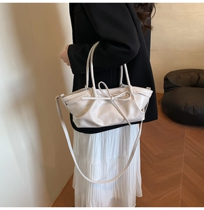 Détail du sac cabas en similicuir crème avec nœud élégant et texture plissée