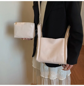 Detail of cream lychee texture tote with matching zipper pouch and metal feet