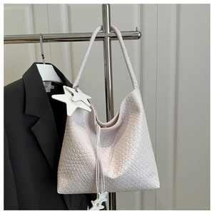 Vue détaillée du sac hobo blanc tissé avec pendentifs étoile et texture tressée