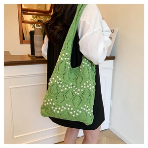 Détail du sac cabas vert en maille orné de perles blanches et d'un tissage ajouré