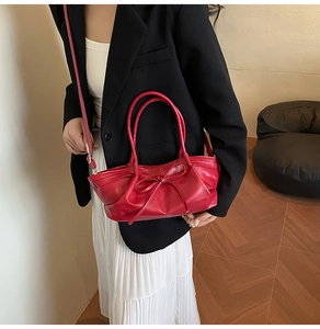 Détail d'un sac cabas en cuir PU rouge avec nœud décoratif et plis élégants