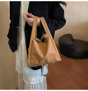 Caramel lychee grain bucket bag with gold hardware shown on model in stylish interior