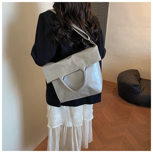 Detail of soft leather tote bag with large capacity and reinforced handle on a model