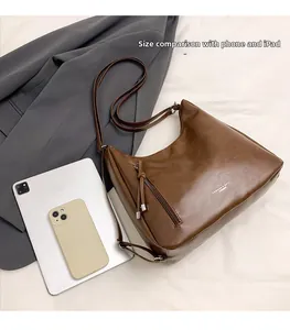 Detailed interior view of dark brown hobo bag showing capacity with tablet and phone