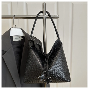 Détail du sac hobo tissé noir montrant la texture, le charme d'étoile et la grande capacité