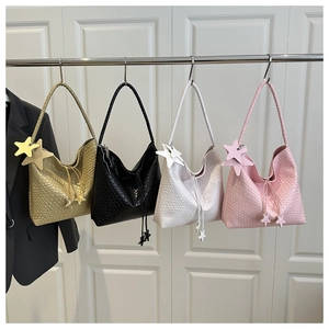 Détail de grands sacs à bandoulière tissés en quatre couleurs avec charms étoiles et cordons