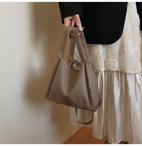 Close-up of brown pebbled leather bucket bag with metal studs and minimalist branding