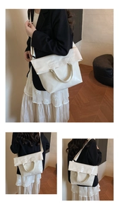 Detail of soft cream white tote bag showing fold-over closure and adjustable strap