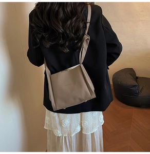 Brown lychee texture bucket bag shown as a crossbody on a model for daily commute style