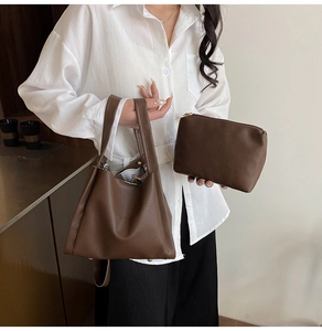 Detail of dark brown lychee leather bucket bag set with tote and zipper pouch
