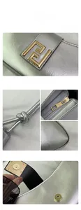 Détail du sac argenté métallisé avec boucle dorée et bandoulière à nœud élégante