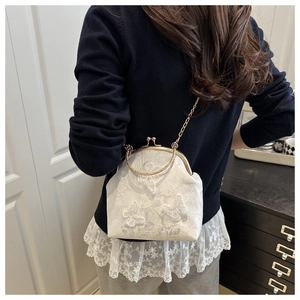 Detail of white lace shell bag featuring 3D butterfly embroidery and metal handle