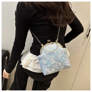 Detail of light blue vintage kiss-lock bag featuring butterfly and floral embroidery