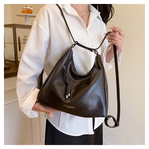 Detail of vintage dark brown faux leather hobo bag with adjustable strap and side zipper