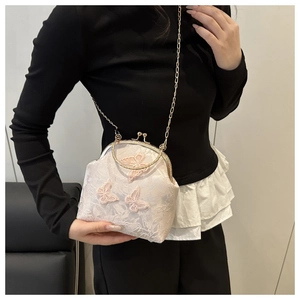 Détail du sac coquille en dentelle blanche avec broderie papillon 3D et poignée anneau