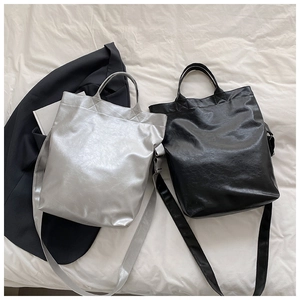 Flat lay of soft synthetic leather tote bags in silver and black with pleated textures