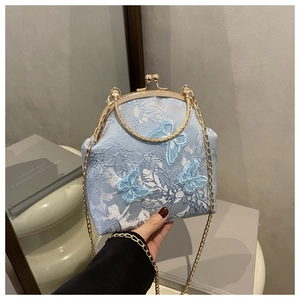 Detail of light blue jacquard bag with 3D butterfly embroidery and vintage metal frame