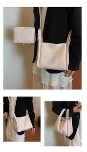 Detail of cream-colored lychee leather bucket bag set with wide strap and pouch