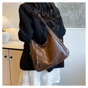 Detail view of large dark brown leather hobo bag with adjustable strap and side zipper
