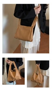 Detail of brown litchi pattern leather bag with gold rivets and dual strap design
