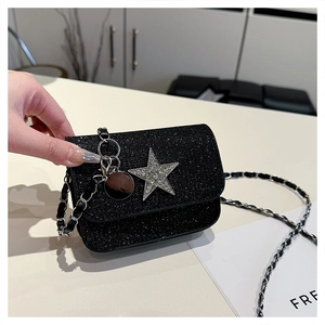 Dettaglio di mini borsa nera con paillettes, grande stella di strass e tracolla a catena
