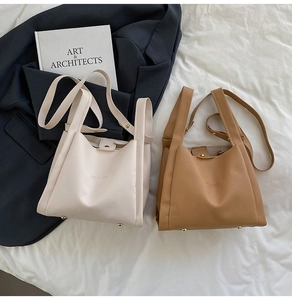 Detailed view of cream and brown pebble leather bucket bags with golden metal feet studs