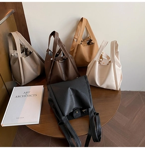 Litchi pattern bucket bags in five neutral colors displayed on a wooden table