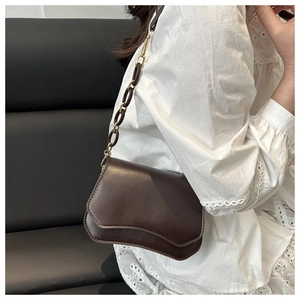Detail of vintage dark brown leather shoulder bag with wavy flap and resin chain strap