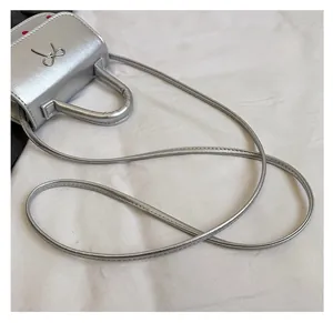 Vue détaillée du mini sac argenté avec nœud métallique et bandoulière fine