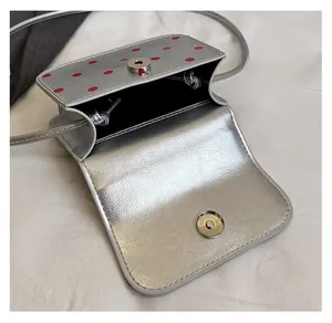 Détail du mini sac argenté avec pois rouges et fermeture magnétique argentée
