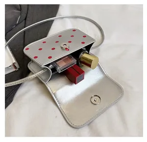 Vue détaillée de l'intérieur du mini sac argenté à pois montrant l'espace de rangement