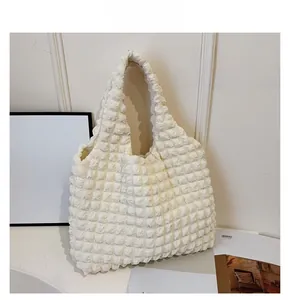 Close-up of beige pleated fabric texture and seamless handle design on large tote bag