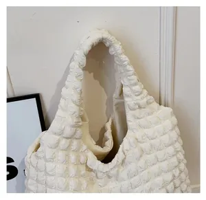 Close-up of cream white bubble texture shoulder bag with wide comfortable strap