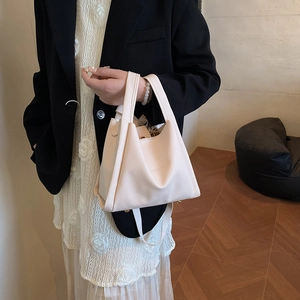 Chic cream-colored bucket bag with lychee texture and adjustable shoulder strap