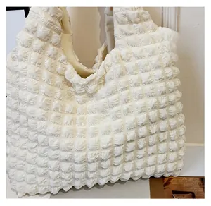 Close-up of beige popcorn fabric tote bag showing detailed 3D pleated texture and soft material