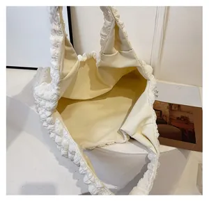 Detailed view of the spacious main compartment inside this white bubble texture tote bag