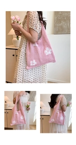 Detail of pink crochet knit tote bag with white flower patterns for summer vacation