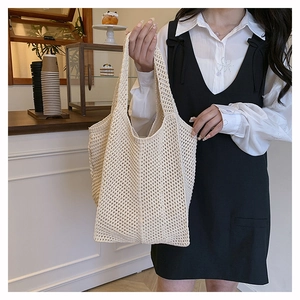 Detail of hollow-out knit tote bag in cream white showing handmade texture and woven mesh