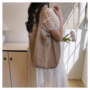 Close-up of khaki crochet knit tote bag with intricate hollow texture and wide strap