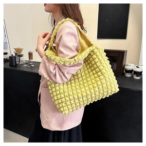 Detail of yellow pleated bubble tote bag showing large capacity and textured fabric