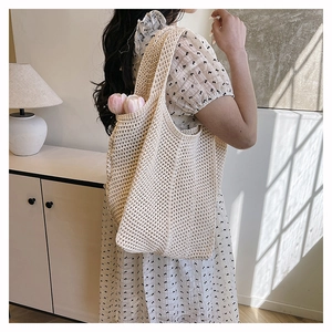 Detail of hollow-out crochet mesh pattern on this beige summer beach tote bag