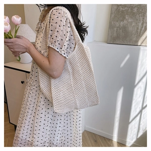 Detail of cream hollow-out knit tote bag with mesh texture and large capacity
