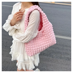 Detailed macro view of pink popcorn fabric texture on a large capacity tote shoulder bag