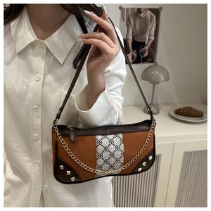 Detail of retro shoulder bag featuring brown leather patchwork and geometric woven straps